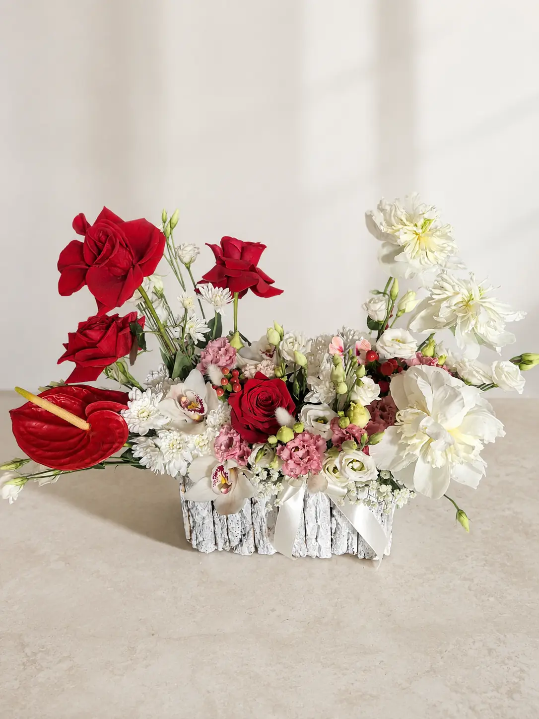 Aranjament floral roșu, alb și roz pe fundal ivory